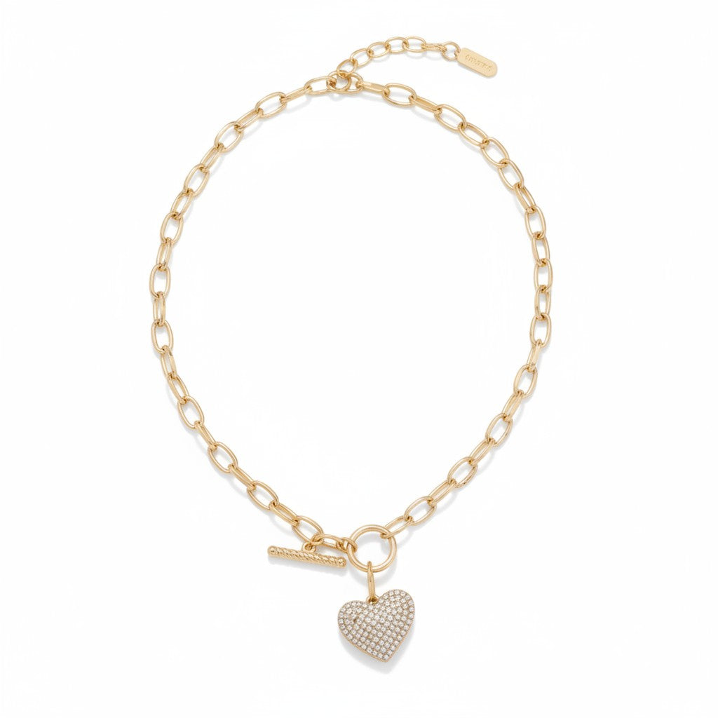 Woman wearing everyday jewelry: minimalist gold pendant necklace and small hoop earrings with white blazer.